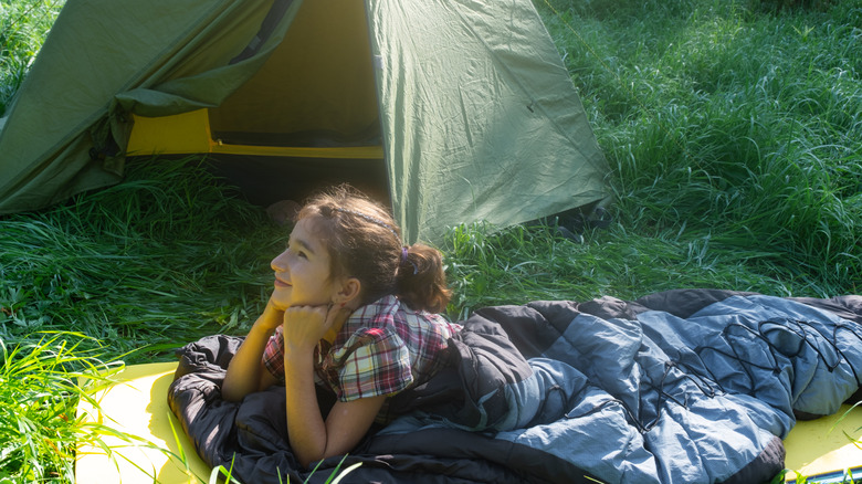 A happy child camper in warm seeping bag