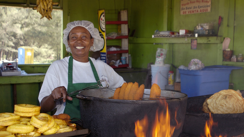 a woman makes traditional snacks at a street-food shack in Puerto Rico in large batches