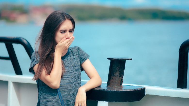 A sick boat passenger holding her hand over her mouth