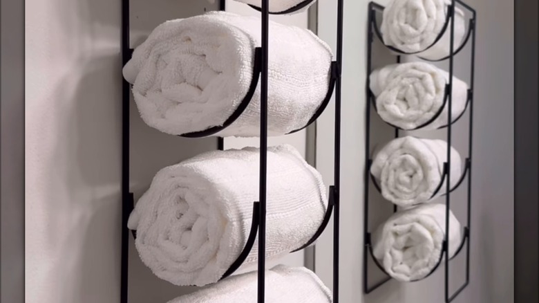 Wine racks being used as towel storage in a bathroom