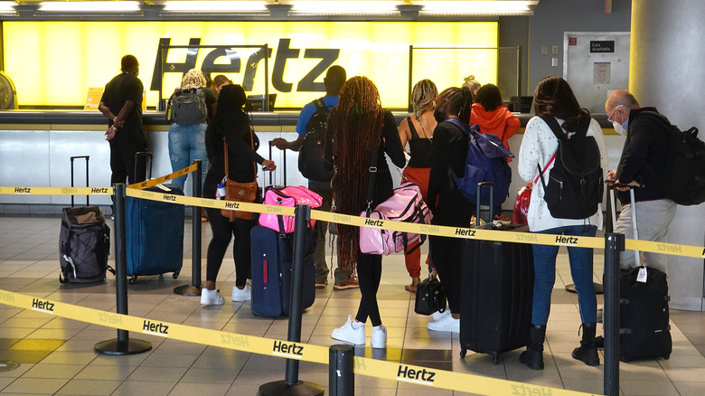 Customers waiting in line at a Hertz counter.