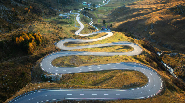 Winding mountain road Maloja Pass Switzerland at golden hour