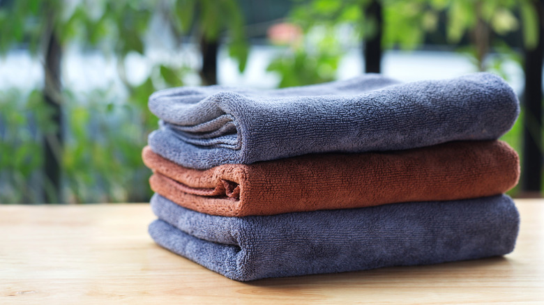 A stack of microfiber towels on a wooden surface