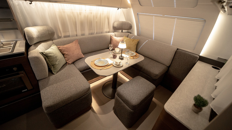 An RV dining table and seating area with fluffy pillows
