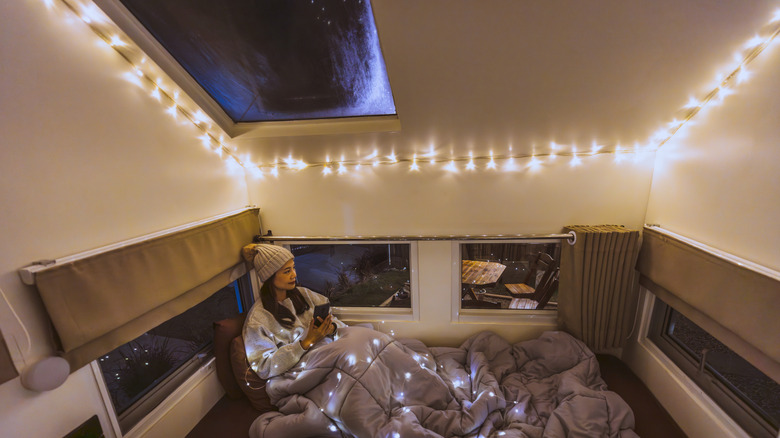 A woman in a camper with twinkle lights