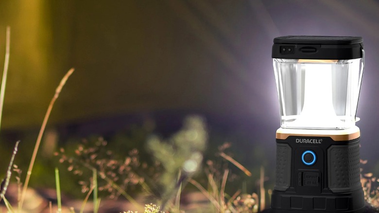 A camping lantern lights up the dark night at a campground.