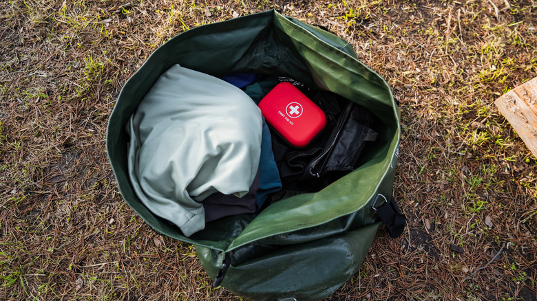 A large waterproof bag packed with camping supplies