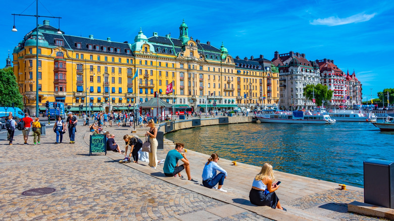 People sitting by the waterfront on a sunny day in Helsinki, Sweden