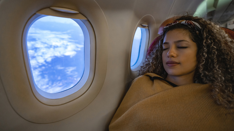 Person sleeping on a plane in a soft wrap