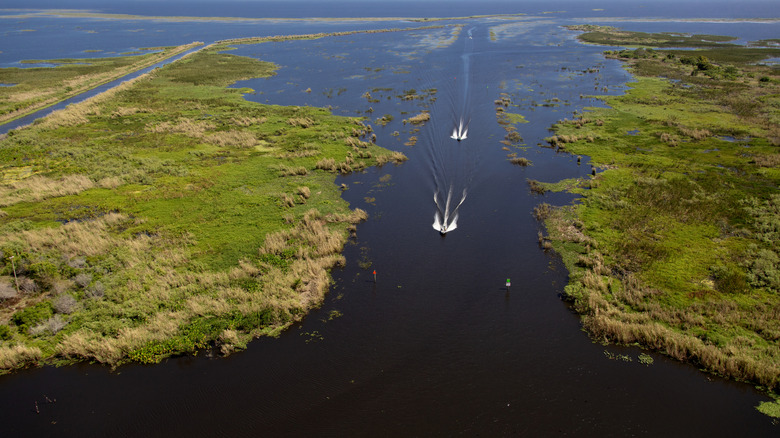 aerial of boats in water with land on either side on Lake Okeechobee