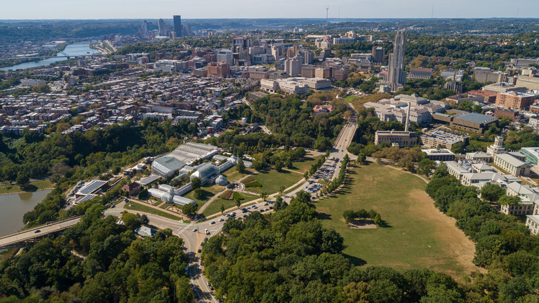 An aerial view of Schenley Park, with the Pittsburgh skyline in the background