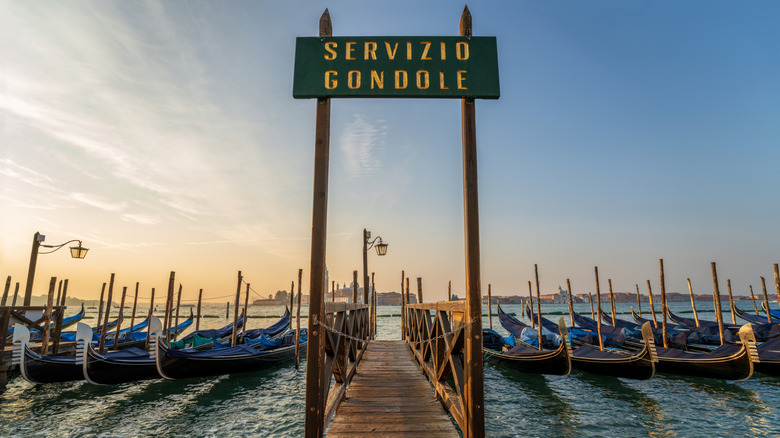 Servizio Gondole sign with line of gondolas at magic hour in Venice