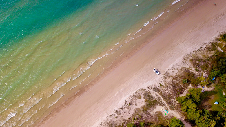 Drone view of the long sandy beach with clear turquoise water at Sauble Beach, Ontario