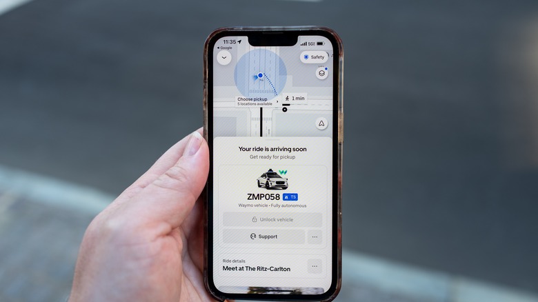 A rider waits for his Waymo autonomous vehicle from Uber
