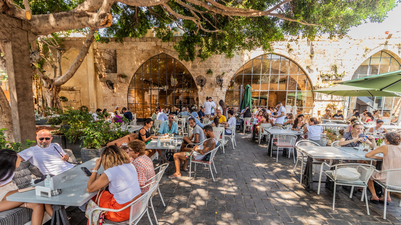 Locals and tourists eating on an outdoor patio at a restaurant in Lebanon