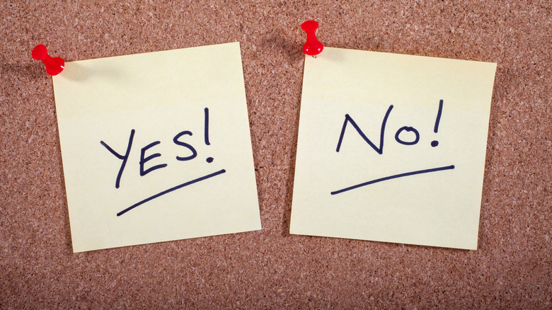 Sticky notes on cork board with "yes" and "no" on them