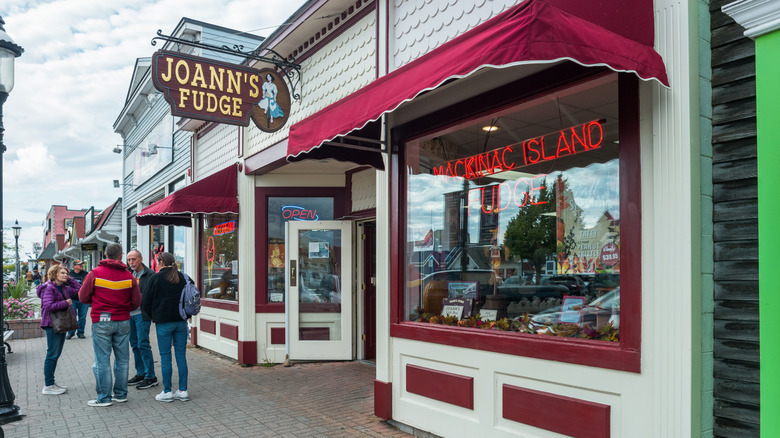 People talk in front of fudge store in downtown Mackinaw City, Michigan