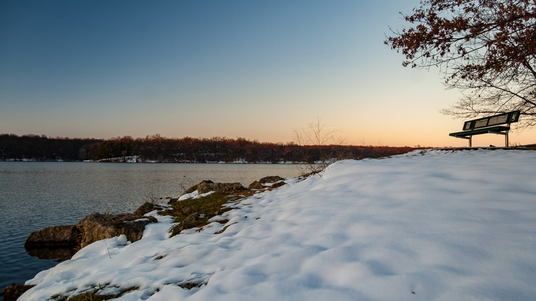 A snowy winter lake scene with picnic bench in Rock Cut State Park