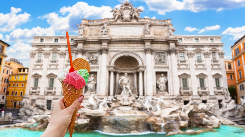 A person holding gelato cone with backdrop of Trevi Fountain
