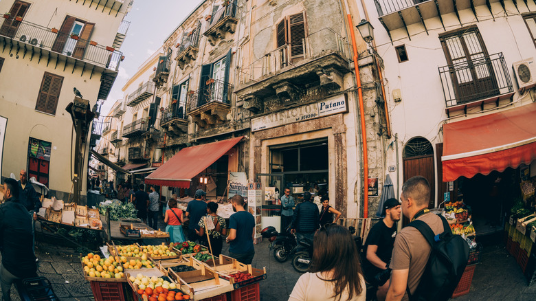 A street market with food vendors and tourists