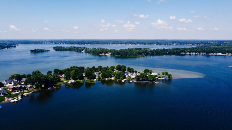 Picturesque view of the Gun Lake with green woody coastline in Michigan