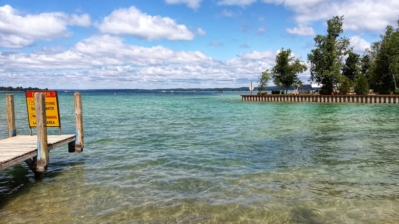 Summertime view of the sun and clear blue water at Torch lake in Michigan