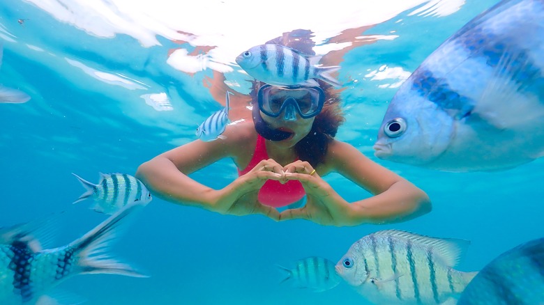 Snorkeler making heart hands 