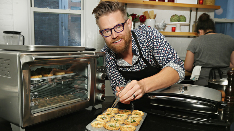 Chef Richard Blais inspects pastries by an oven