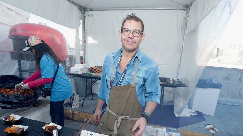 Chef John Tesar in a tent at a BBQ cookout