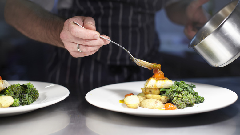 A chef puts the finishing touches on a dish