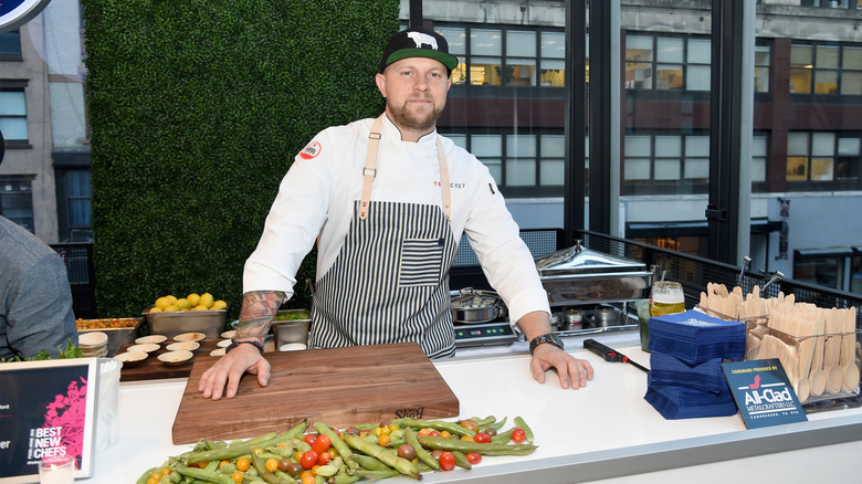 Chef Jeremy Ford with a cutting board and vegetables