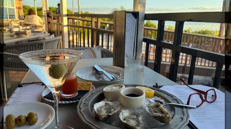 A chilled martini and plate of raw oysters on the half shell on Oystercatchers' waterfront patio in Tampa
