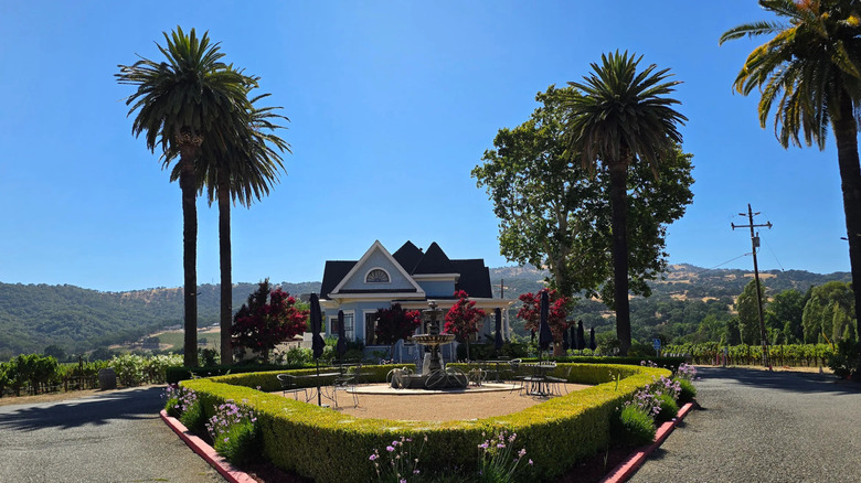 Exterior of Vezér Family Vineyard Blue Victorian with fountain and trees