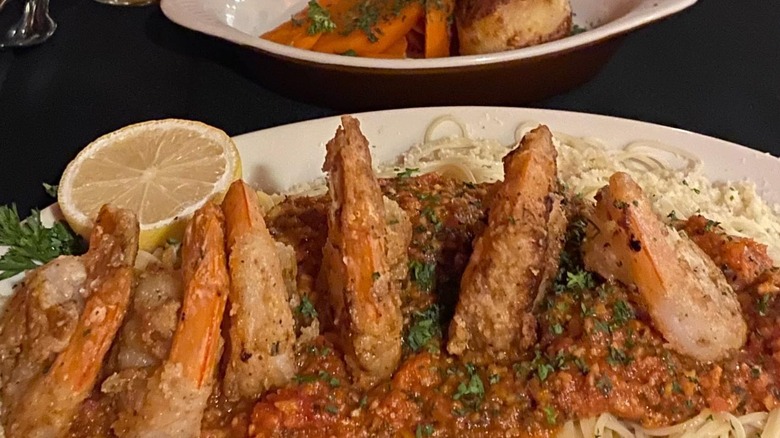 A plate of shrimp pasta on a black table