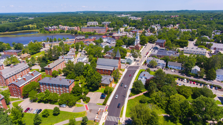 Aerial view of downtown Exeter as trees and Georgian buildings line waterfront