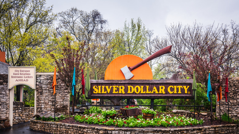 A sign reading Silver Dollar City, complete with a statue of an axe.