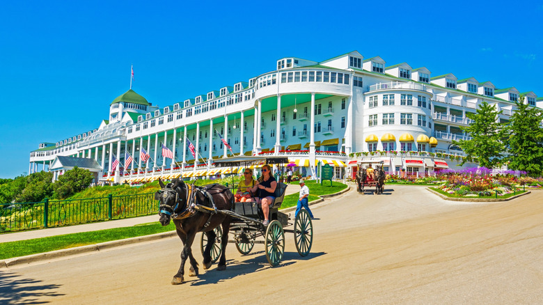 Grand Hotel on Mackinac Island, a full view of the hotel with horse-drawn carriages on the driveway