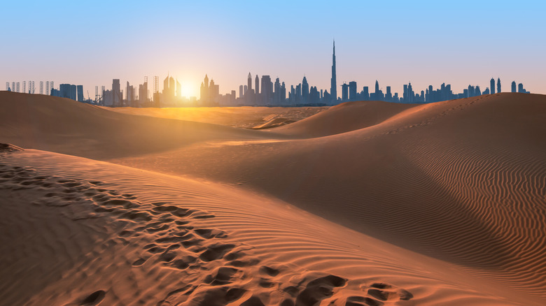 Skyline of Dubai with sand dunes in the foreground, United Arab Emirates