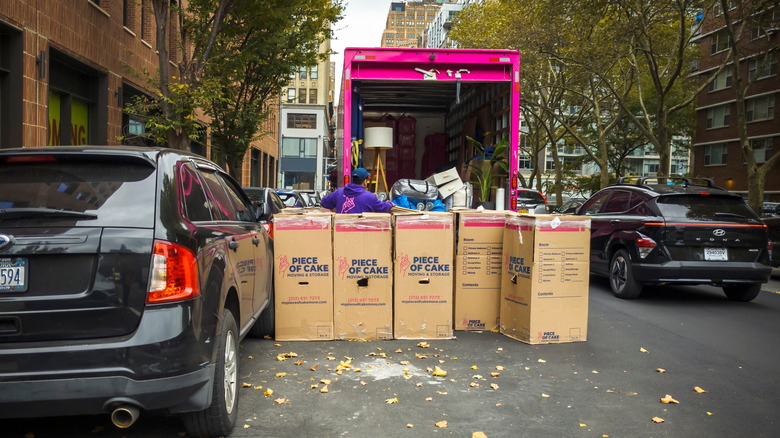 Removalists loading boxes into a moving van on a street in Chelsea, New York City