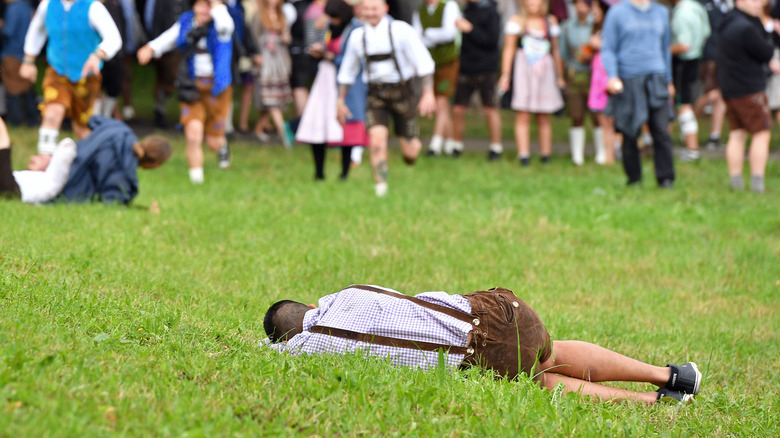 A visitor in traditional Bavarian clothes takes a rest beside the beer tents at Oktoberfest
