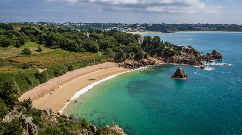 A beach and turquoise water on the island of Jersey