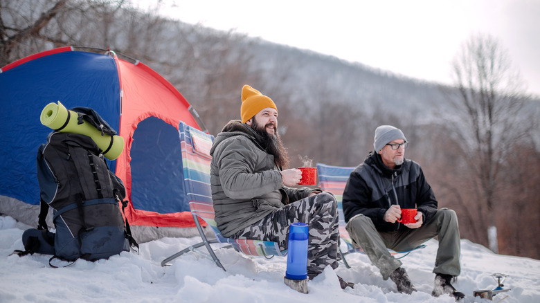 Two campers sit and enjoy the cold weather