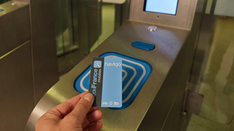 Close-up of a French Paris Metro Navigo pass being swiped against a blue card reader