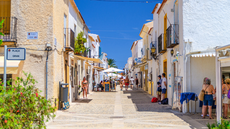 Tourists walking along a pedestrian street on Tabarca Island, Spain