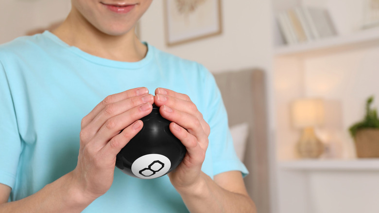 A child holds a Magic 8 Ball toy