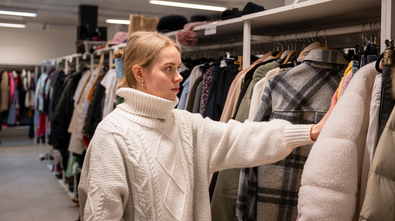 Person looking at coats and jackets in a thrift store