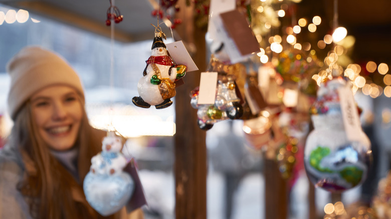 Smiling woman looking at a display of holiday ornaments