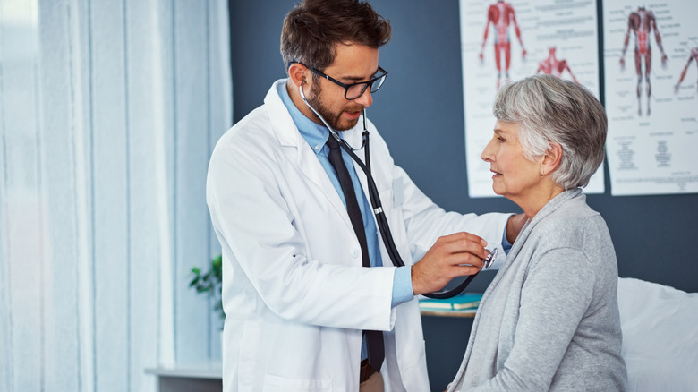 Doctor with stethoscope with an elderly woman