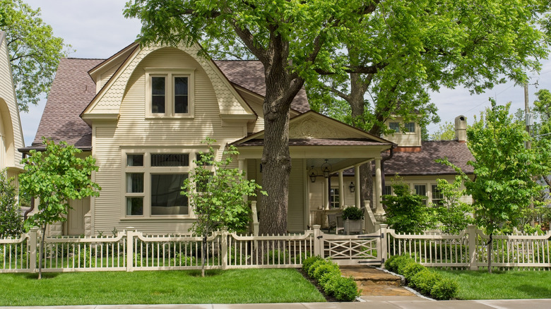 House in Arkansas with fence in front and surrounded by green trees