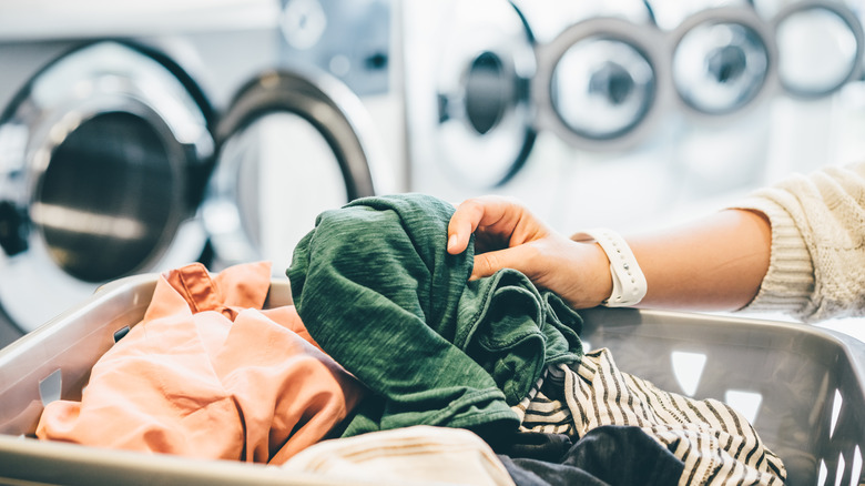 Unloading clothing from a suitcase at a laundromat